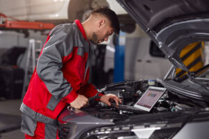 hombre técnico arreglando problemas electrónicos de coche