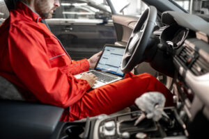 hombre técnico con portátil reprogramando un coche
